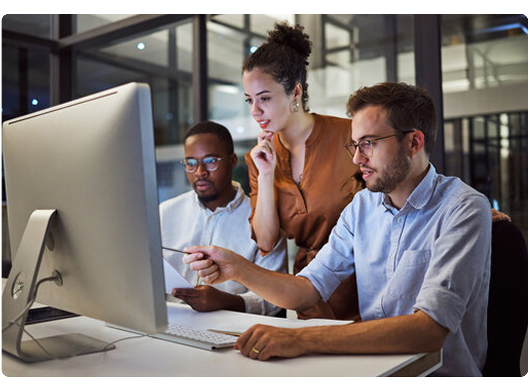 Three workers in front of a computer