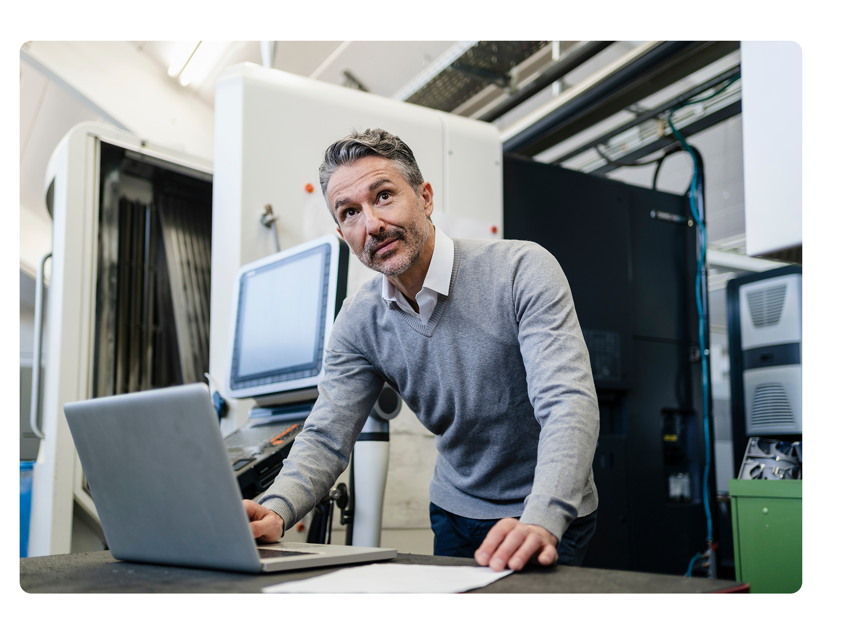 Manufacturing employee using laptop in a complex environment