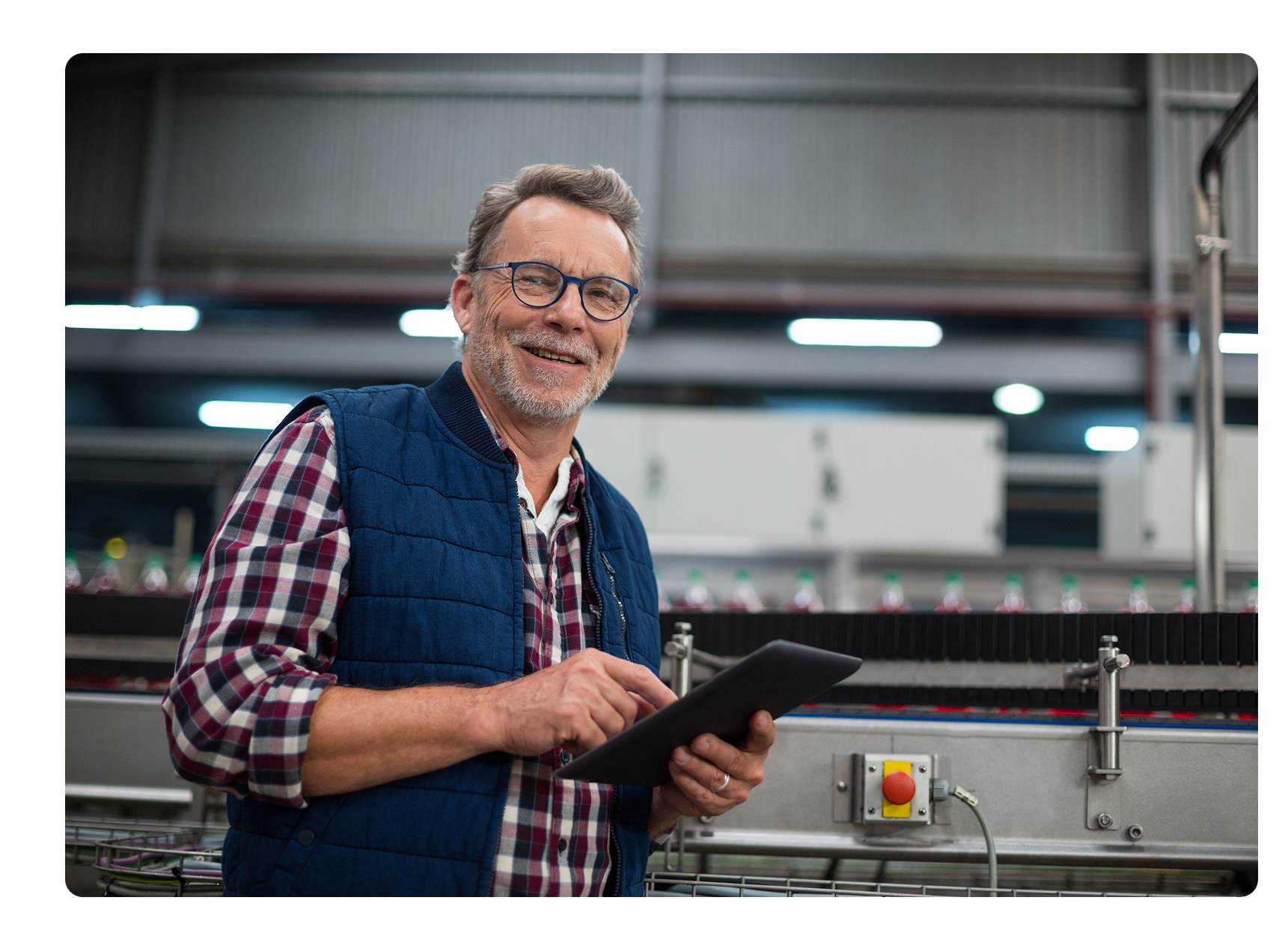 man holding a tablet in a manufacturing facility