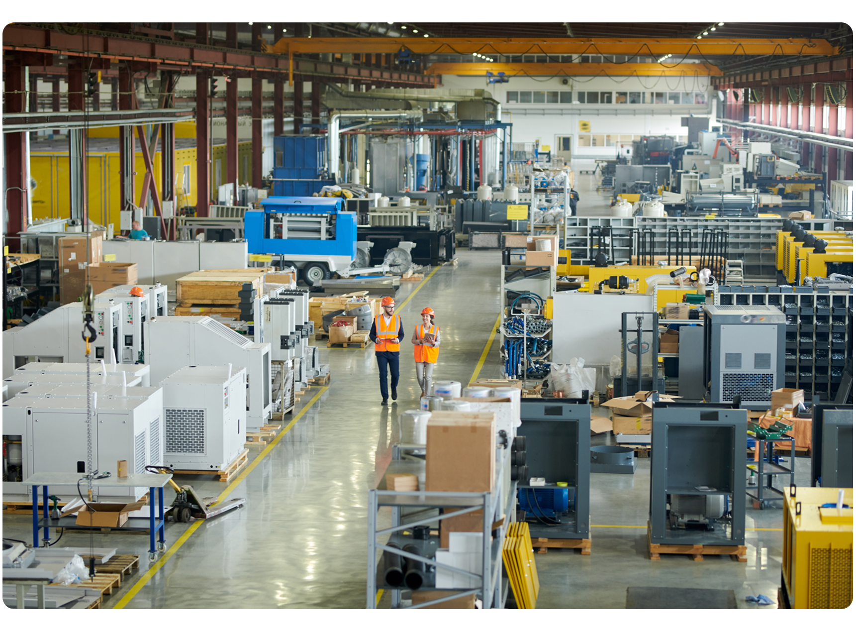 Two manufacturing employees walking in a large plant