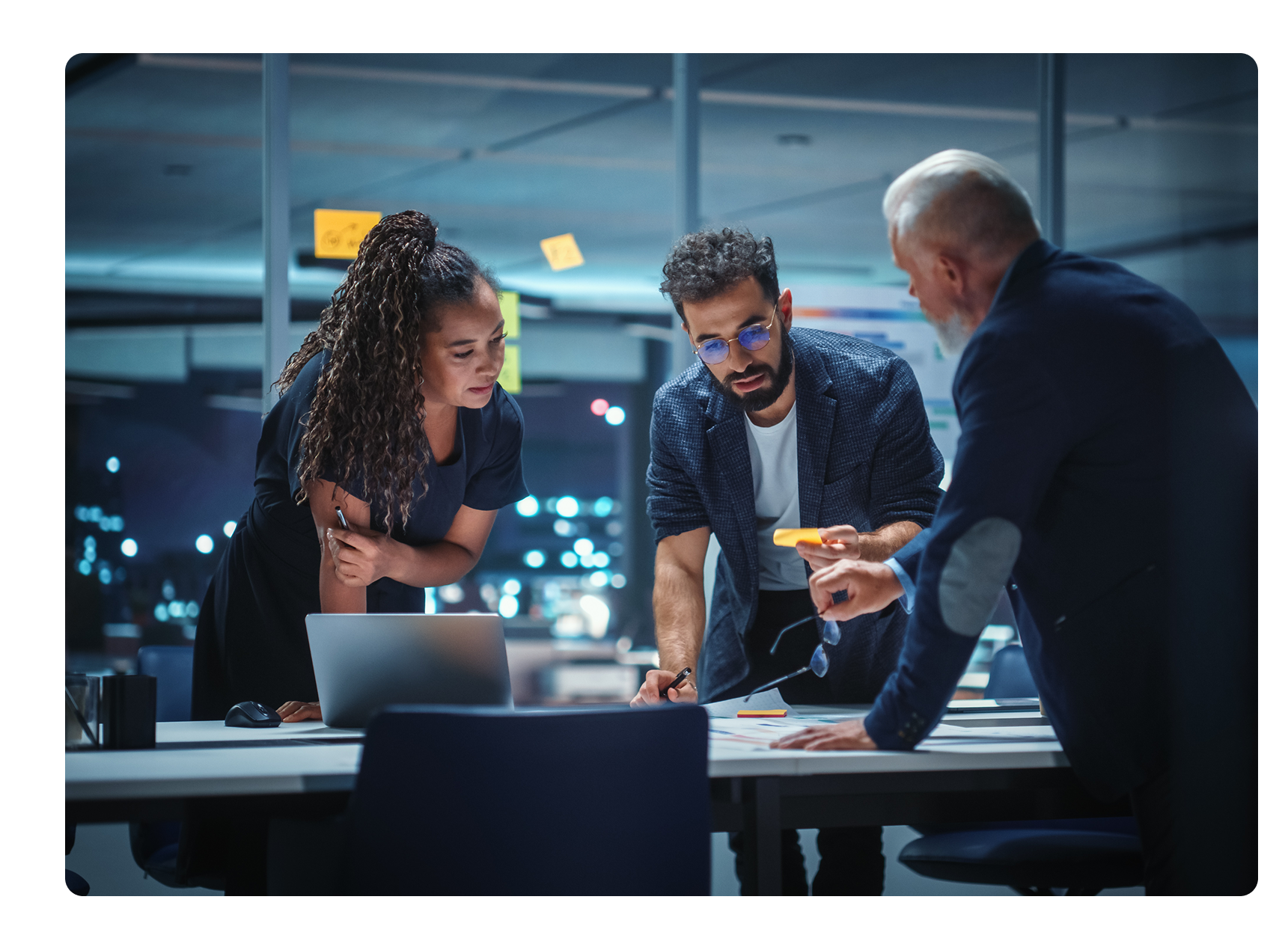 technology partners standing over a conference table talking